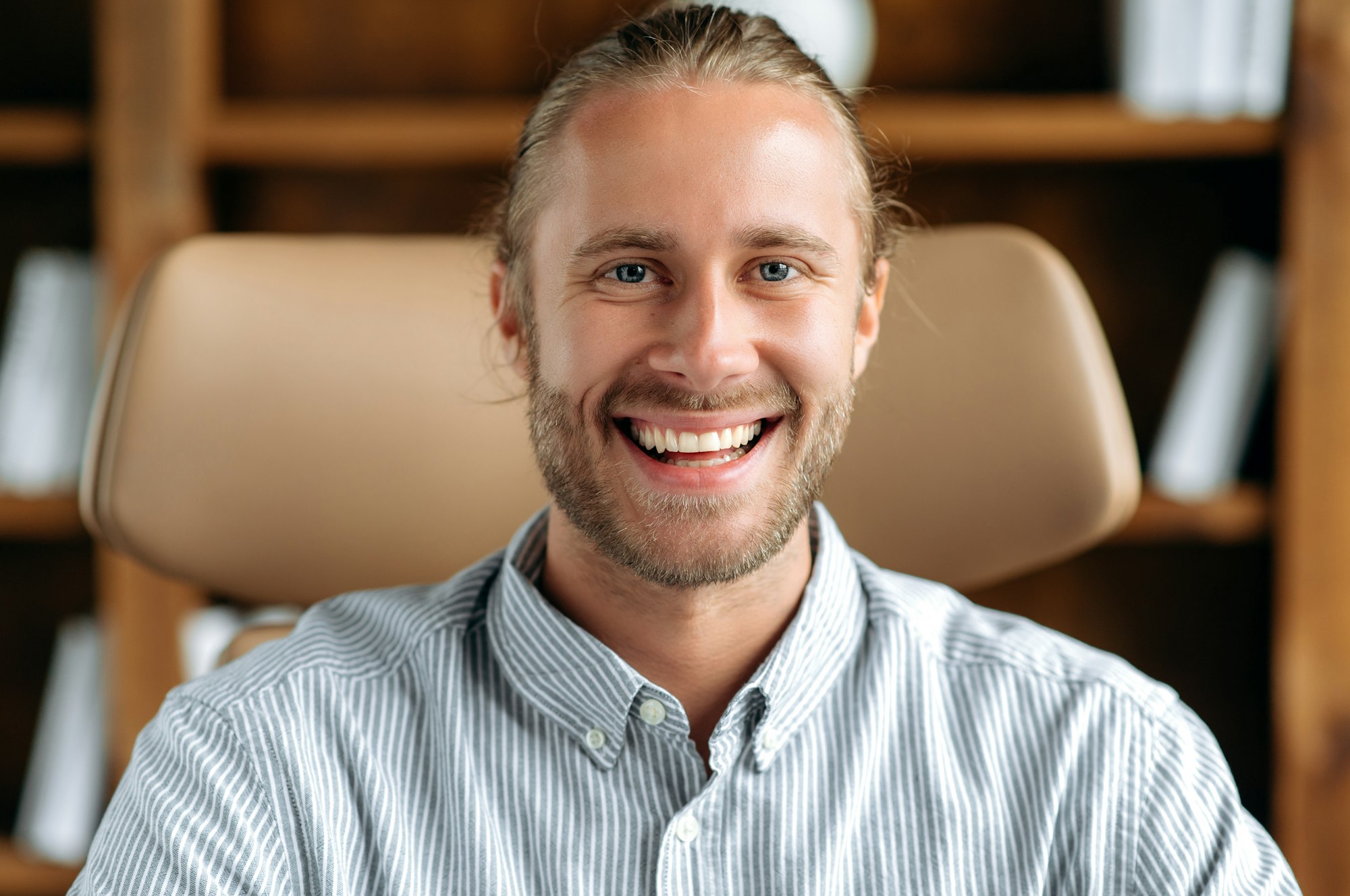 Close-up headshot of attractive positive successful young caucasian man, smiling friendly