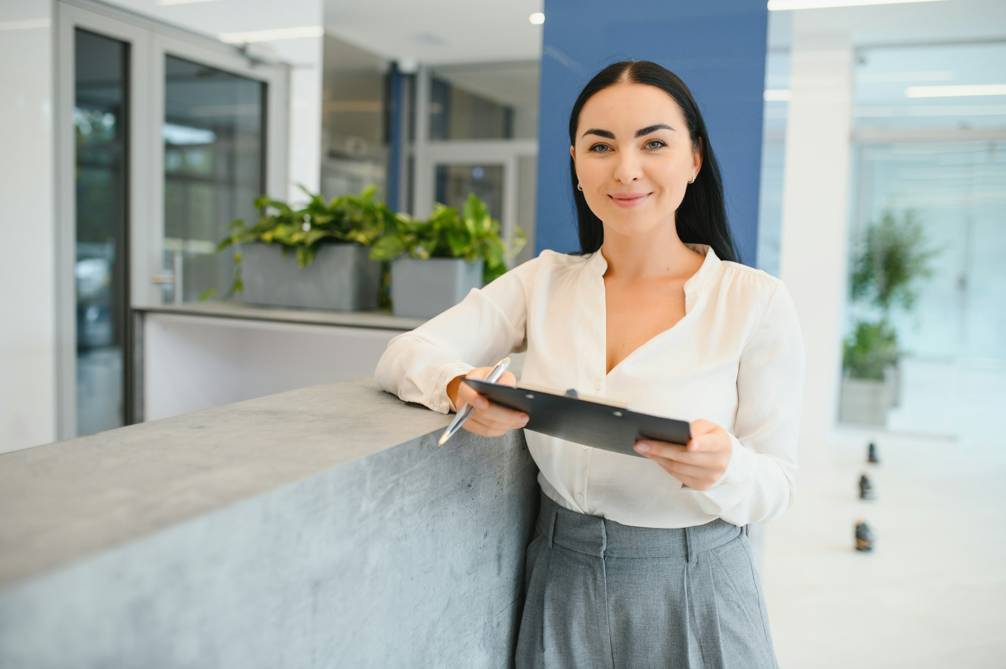 Portrait of beautiful receptionist near counter in hotel