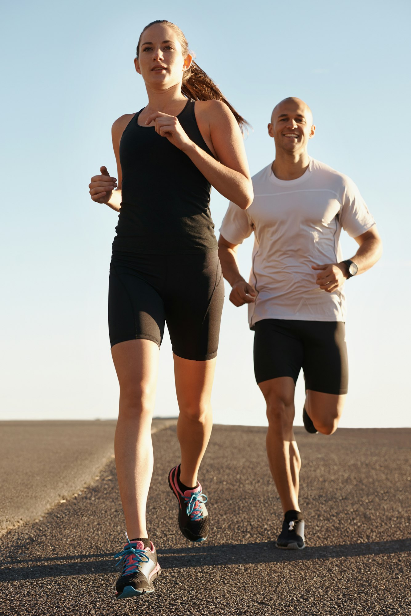 Running together is their thing. Shot of a young couple running along a road.